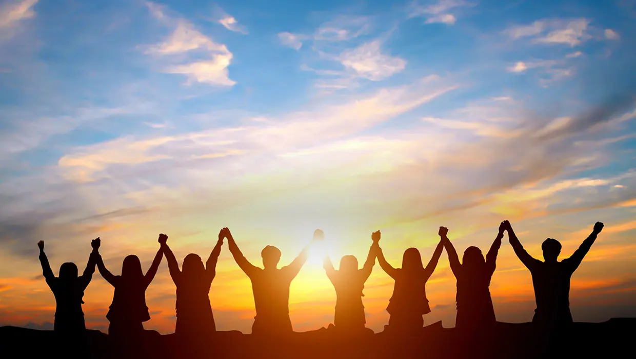 A group of people holding hands in the air.