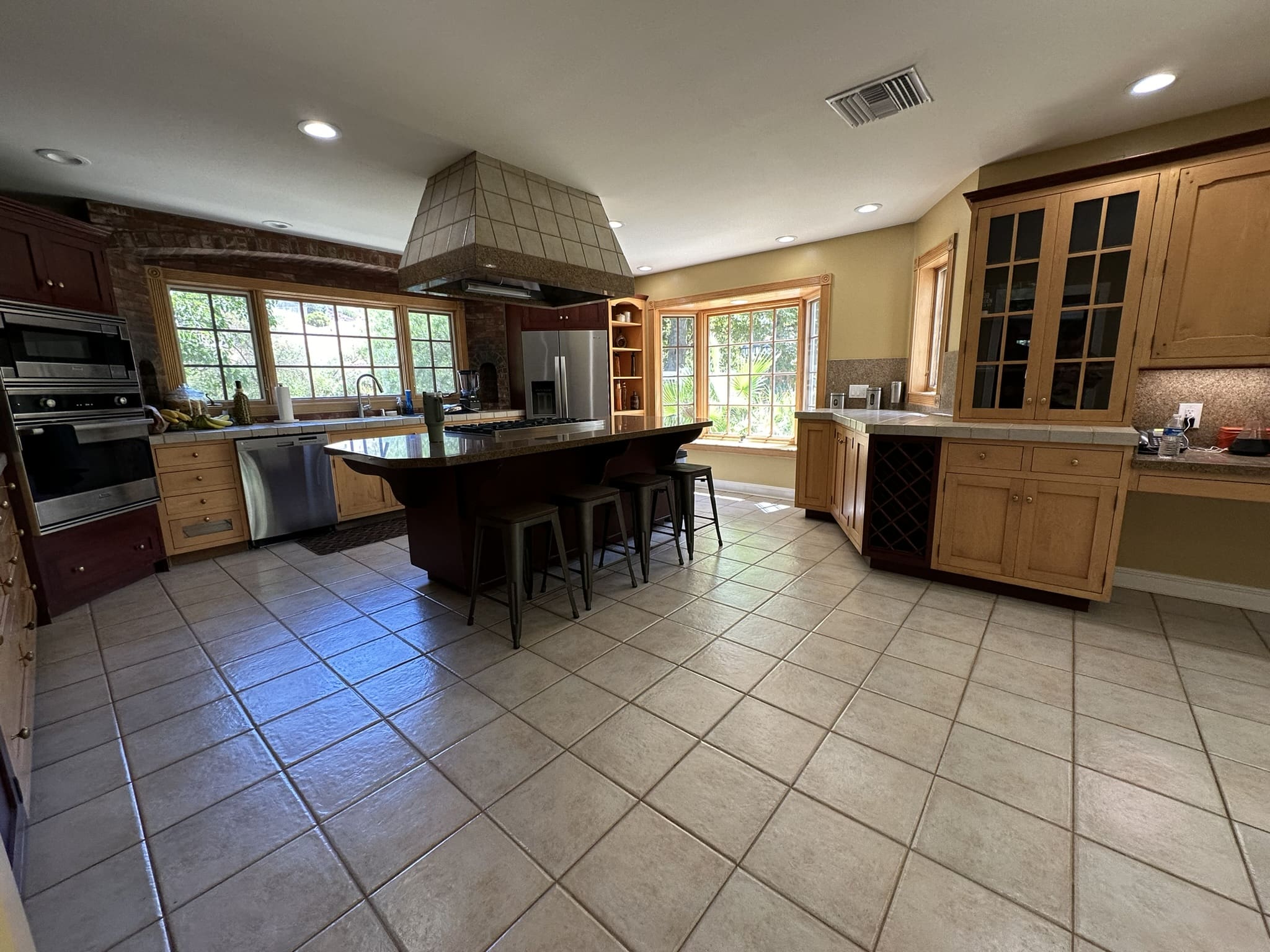 A large kitchen with tile floors and wooden cabinets.