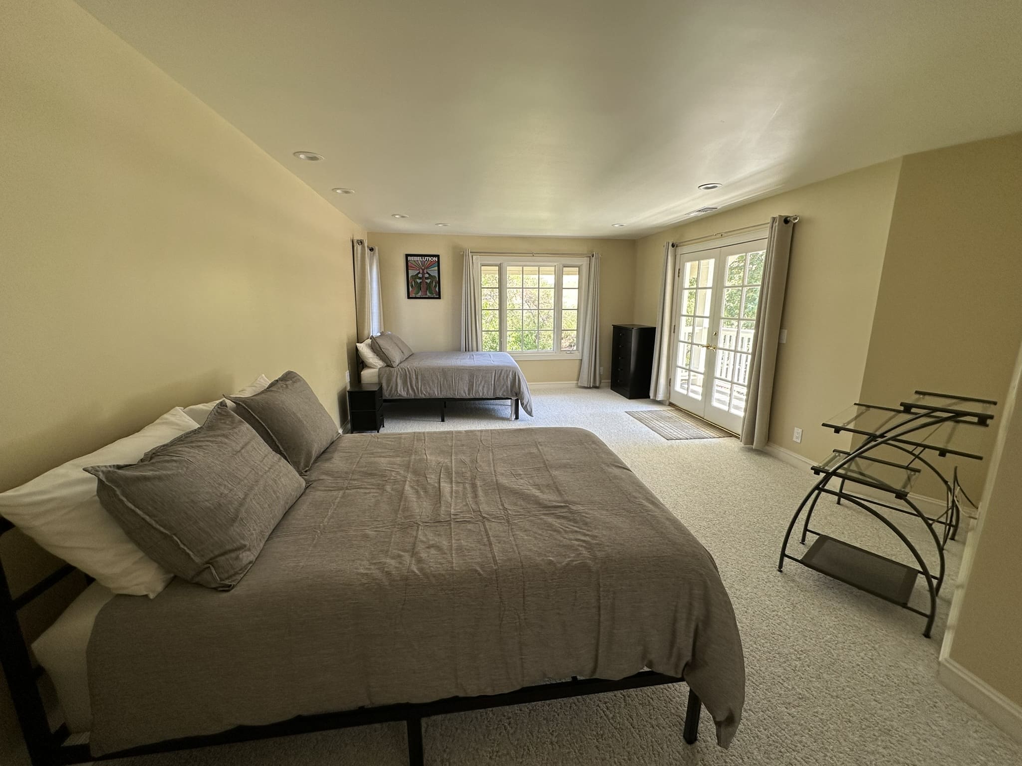 A bedroom with two beds and a large window.