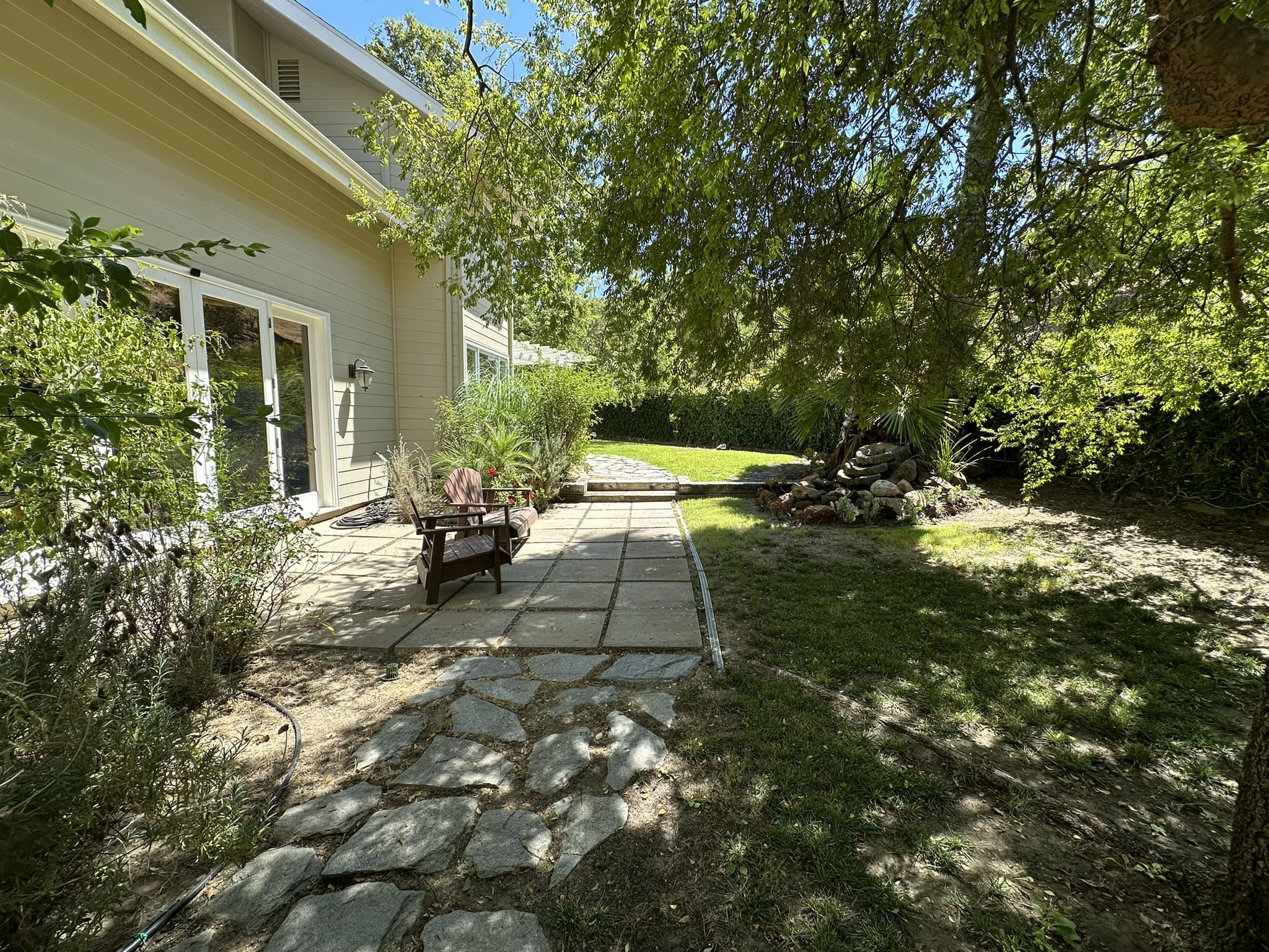 A walkway in the middle of a yard with trees.